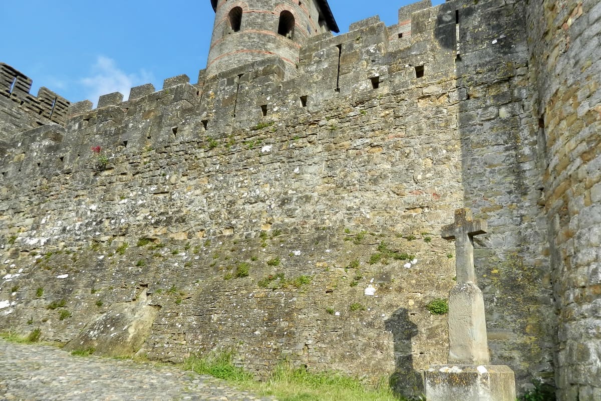 The double walls and conical-roofed towers of the Cité de Carcassonne at sunset, in Aude, southern France — a medieval fortified city restored by Viollet-le-Duc and UNESCO-listed since 1997